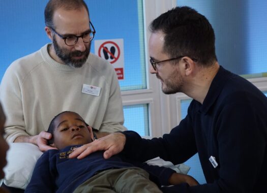 6 year old boy receiving osteopathic treatment by two male osteopaths at the OCC.