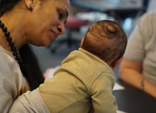 Baby receiving osteopathic treatment, practitioner photographed smiling